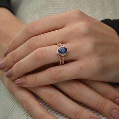 a woman's hand with a ring on it and a blue stone in the middle