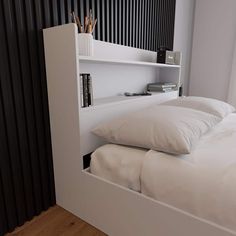 there is a bed with white sheets and pillows in the corner next to a book shelf