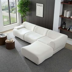 a living room with a large white couch in it's center area and a book shelf on the far wall