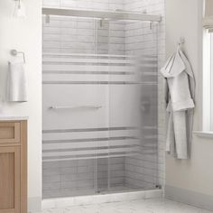 a bathroom with white tile and wooden cabinets