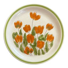 an orange and green plate with flowers painted on it