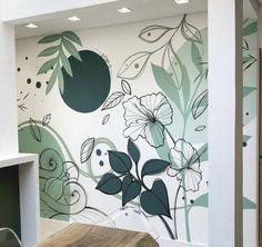 the wall is painted with flowers and leaves on it, along with a wooden table