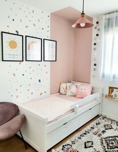 a pink and white bedroom with polka dot wallpaper on the walls, a small child's bed