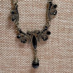 Step Back In Time With This Ornate Necklace Done In Bronze And Black Faceted Crystals. Black Crystal Stations Run Along The Bronze Chain And A Lobster Claw Clasp Finishes The Piece. This Necklace Brings A Feeling Of Timeless Elegance . Black Gothic Necklace With Lobster Clasp, Gothic Black Necklace With Lobster Clasp, Elegant Black Necklaces For Evening, Elegant Black Necklace For Evening, Black Metal Necklaces With Lobster Clasp, Black Metal Necklaces, Elegant Metal Necklace With Black Beads, Vintage Black Dangle Jewelry, Vintage Black Necklace For Formal Occasions