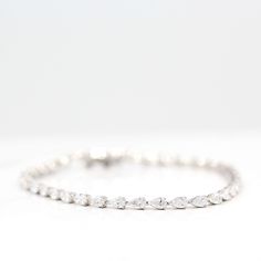 The Marquise Lab Grown Diamond Tennis Bracelet in white gold against a white background Classic Marquise Diamond Bracelet With Brilliant Cut, Marquise Diamond Bracelets With Diamond Accents, Classic Marquise Diamond Bracelet In White Gold, Diamond Tennis Bracelet With Marquise Prong Setting, Classic Marquise White Gold Diamond Bracelet, Classic Silver Marquise Diamond Bracelet, Classic Marquise Diamond Cut Bracelet, White Gold Marquise Diamond Bracelet For Wedding, Fine Jewelry Marquise Diamond Bracelet For Wedding