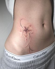 a woman's stomach with a flower tattoo on it