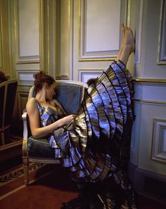 a woman sitting in a chair reading a book