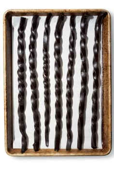 an old wooden frame with many black braids in it