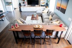 a living room filled with furniture and a wooden table in front of a large couch