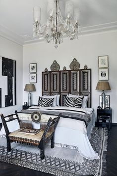 a bedroom with a bed, chandelier and pictures on the wall