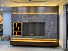 an empty room with marble walls and shelves on the wall, in front of a staircase