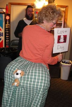 a woman holding a sign that says lost dog on it with a stuffed animal in her lap