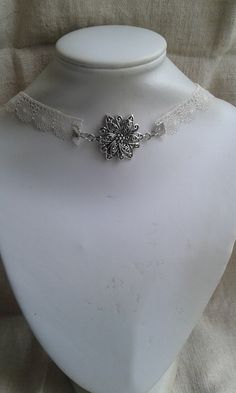 neck collar made with an ivory "flowers" lace ribbon and a flower connector, silver metal Dimensions: ribbon: 1.5 cm wide, flower: 3 cm in diameter Elegant Silver Lace Jewelry, Elegant White Flower Choker, Ribbon Choker Necklace For Weddings, Elegant Choker With Flower Charm, Ivory Flowers, Lace Ribbon, Choker Necklaces, Neck Collar, A Flower