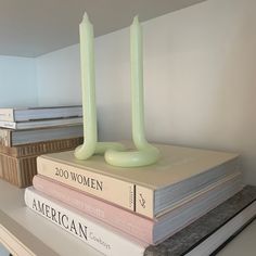 a stack of books with two candles on top