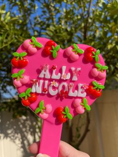 a pink heart shaped lollipop with cherries on it and the words ally nicole