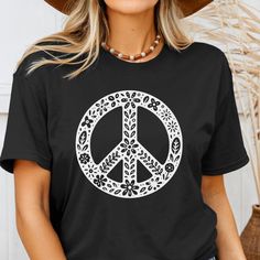 Floral Peace Sign TShirt Boho Fashion Floral Peace Sign Graphic Tee Bigfoot Tshirt *UNISEX FIT* Dress up in boho fashion with our Floral Peace Sign Graphic Tee. This unisex fit shirt features a simple yet eye-catching floral peace sign design, perfect for adding a touch of retro charm to any outfit. Express your love for all things peace and nature with this stylish t-shirt. Our buttery soft Bella + Canvas shirts and Tanks are manufactured in South America or Los Angeles, with components from the USA & Hand printed in the USA. To shop the rest of our Women's Short Sleeve collection, click here.  Details  Available in sizes S-2XL 11 Color Options: Mauve, Navy, Black, Royal, Maroon, Green, Dusty, Peach, Dark Grey, Military Green, Slate Fabrication is poly/cotton blend Printed in White Ink Ha Spring Festival Hippie T-shirt, Spring Festival Casual T-shirt, Bohemian Crew Neck T-shirt For Summer, Casual Letter Print Tops For Festivals, Casual Crew Neck Tops For Festival, Casual Relaxed Fit T-shirt For Festivals, Casual Screen Print T-shirt For Festival, Relaxed Fit Crew Neck Top For Festivals, Hippie Letter Print Tops For Spring