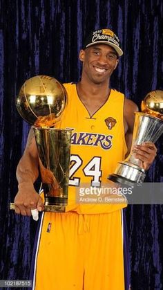 the los lakers basketball player holding two trophies