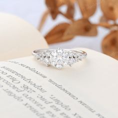 a diamond ring sitting on top of an open book