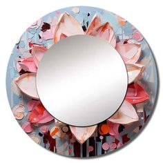 a round mirror with pink and orange flowers on the front, surrounded by confetti