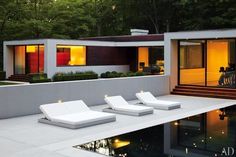 modern house with pool and lounge chairs at dusk