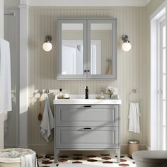 a bathroom with a sink, mirror and towel rack in it's center area