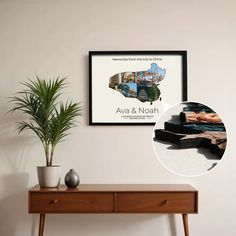 a wooden table with a potted plant on it and a poster hanging above it