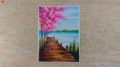 a painting of a pink tree on the side of a wooden wall next to a body of water