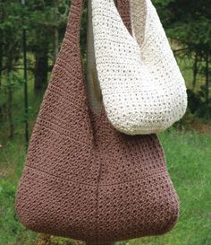 a crocheted bag hanging from a hook in front of some grass and trees