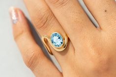 a woman's hand with a ring on it and a blue stone in the middle