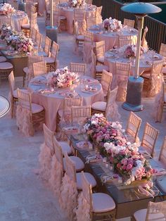 an image of a table set up for a wedding reception with flowers on the tables