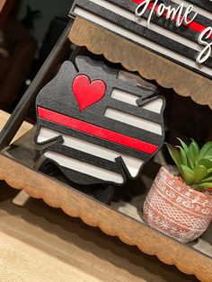 a small potted plant sitting on top of a shelf next to a wooden sign