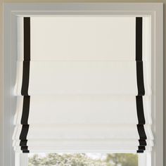 an open window with white and black roman blinds