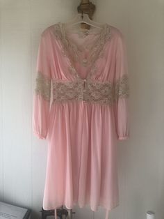 This beautiful vintage pink nightgown and robe is a unique and rare find. This set does have various stains throughout, but if treated with further care it can be a wonderful addition to your vintage collection.  Robe Bust Measurement: 30"  Robe Waist Measurement: 26"  Robe Length: 35"  Nightgown Bust Measurement: 33" Nightgown Waist Measurement: 27" Nightgown Length: 35" Vintage V-neck Wedding Sleepwear, Pink V-neck Nightgown With Lace Trim, Pink Long Sleeve Nightgown For Wedding Night, Vintage V-neck Sleep Dress, Vintage Pink Nightgown For Spring, Vintage Nightgown For Wedding Night, Vintage Pink Sleepwear For Spring, Vintage Pink Sleepwear, Vintage V-neck Wedding Nightgown