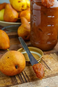 some pears are sitting on a cutting board next to a jar of jam