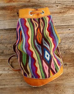 a multicolored bag sitting on top of a wooden floor next to a wall