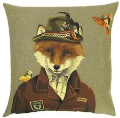 a fox wearing a jacket and hat with birds on it's back, sitting in front of a pillow