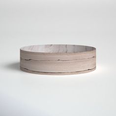 a wooden bowl sitting on top of a white table