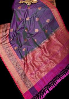 The Purple dual tone Meenakari Antique Zari Butta Pure Banarasi Dupion Silk Saree with two-tone borders is a masterpiece that reflects the timeless beauty of traditional Indian textiles. Crafted from luxurious Banarasi dupion silk, this saree exudes opulence and sophistication. Adorning the saree are exquisite Meenakari Antique Zari Buttas, meticulously woven into the fabric with intricate detailing and precision. The Meenakari work adds a touch of vibrancy and charm to the ensemble, creating a mesmerizing visual display. The saree is further enhanced by its dual-tone borders, which add depth and richness to the overall design. The contrasting borders frame the saree beautifully, adding an element of elegance and grace. Draping this saree is an experience of indulgence and refinement, wher Dupion Silk Saree, Embroidery Fashion Detail, Dupion Silk, Indian Textiles, Embroidery Fashion, Traditional Indian, Blouse Fabric, The Purple, Fashion Details