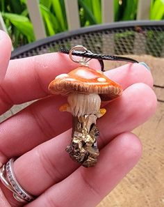 Fairies! Here is your dream necklace! A hand scuplted, gorgeously detailed mushroom growing from a real crystal shard! What can make this even better? It glows in the dark! Made from polymer clay and crystal shard then coated with an enamel gloss for durability and shine. This is water-resistant but I wouldn't recommend wearing it in water. Strung from an 18" black leather cord. All orders will be shipped within 3 business days of payment unless otherwise noted. In an effort to go green, I do no Clay Mushroom Pendant, Whimsical Brown Jewelry For Gifts, Whimsical Brown Jewelry Gift, Whimsical Brown Jewelry For Gift, Whimsical Bronze Jewelry For Gifts, Fantasy Copper Jewelry As Gift, Polymer Clay Mushroom Design Jewelry Gift, Fantasy Polymer Clay Jewelry As A Gift, Unique Adjustable Mushroom-shaped Jewelry