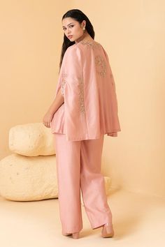 Rose gold chanderi cape featuring zari embroidered floral motifs. Comes with inner peplum top and pant.
Components: 3
Pattern: Embroidered
Type Of Work: Zari, Pearl, Sequin
Neckline: Cape: Open, Top: V-neck 
Sleeve Type: Cape: Cape sleeves
Fabric: Chanderi
Color: Pink,Gold
Other Details: 
Attached lining
Weight: 2 kgs
Occasion: Cocktail,Reception - Aza Fashions Embroidered Cape, Cocktail Reception, Cape Sleeves, Floral Pants, Floral Motifs, Pant Set, Open Top, Set For Women, Aza Fashion