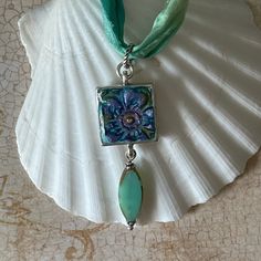 * Hand painted embossed resin clay, sealed with resin topcoat  * Pendant is .999 fine silver plated pewter cast in the US * 18" Sari ribbon with 3" extender chain * Czech glass bead * All pieces ship in a gift box, ready for gift giving! * Please follow all care instructions included with all Bohemian Happiness jewelry to ensure your jewelry always looks its best!  Bohemian Happiness Jewelry is one-of-a-kind due to the nature of being handmade. No two pieces are alike! All jewelry in made in the Hand Painted Green Spiritual Jewelry, Green Hand Painted Spiritual Jewelry, Spiritual Hand Painted Green Jewelry, Turquoise Hand Painted Jewelry Gift, Hand Painted Turquoise Jewelry Gift, Bohemian Silver Resin Jewelry, Artistic Blue Czech Glass Jewelry, Artistic Glass Jewelry Nickel-free, Artistic Hand Painted Turquoise Jewelry