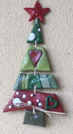 a ceramic christmas tree ornament hanging on a wall