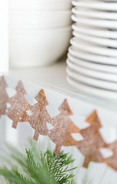 christmas decorations on a shelf with plates and cups in the backgroung area