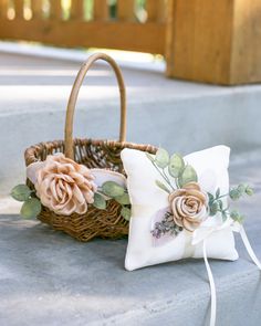 a basket with flowers on it sitting next to a pillow and flower pincuss