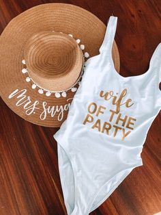 a white one piece swimsuit with the words wife of the party printed on it