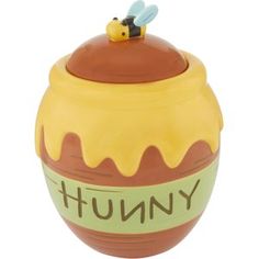 a yellow and brown ceramic jar with a bee on top that says,'yummy '