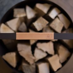 a bowl full of chopped wood with a wooden stick sticking out of the top one