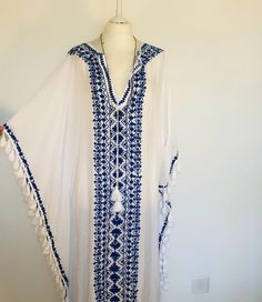 A Beautiful Boho Kaftan,Maxi Dress ,Cover Up. Long and Embroidered and Floaty,Perfect for Poolside,Beach holidays or Parties.  In Fresh White Cotton Viscose Mix,with a Lovely Traditional Indigo Blue Embroidery and Tassels. This dress flows loosely with a V neckline and a softly draped silhouette. This dress is really versatile for Holidays , lunches , special events and celebrations. It feels loose and floaty to wear , and easy ro roll up to take away. One Size S M L XL. UK 10 to 20   US 6 to 16 70s Kaftan, Hippie Maxi Dress, Summer Cover Up, Beach Kaftan, Kaftan Maxi Dress, Blue Embroidery, Dress Beach, Festival Dress, Beach Holiday