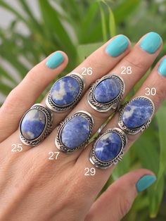 "Peruvian rings, adjustable to every ring size. These blue gemstone rings are crafted out of alpaca silver and decorated with Sodalite stone for calmness and emotional balance. ♡ With every purchase you directly support a handicraft artisan in Peru! CHOOSE YOUR RING Every ring is unique because we only use natural stones. Pick your favourite(s) and select the corresponding number(s) when ordering. You'll receive exactly the same as shown in the pictures. More ethnic (gemstone) rings: https://www Bohemian Oval Crystal Ring With Natural Stones, Oval Bohemian Crystal Ring With Natural Stones, Bohemian Blue Ring With Large Stone, Bohemian Oval Gemstone Jewelry, Bohemian Jewelry With Large Oval Cabochon Stone, Unique Adjustable Oval Crystal Ring, Bohemian Oval Crystal Ring Nickel-free, Bohemian Oval Crystal Ring Nickel Free, Adjustable Oval Crystal Ring