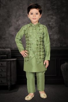 Enhance your little one's appearance on special occasions with this exquisite three-piece kurta pyjama set. The cotton kurta, adorned in a mehendi green hue, features plain patterns that add an elegant touch. The matching overcoat, embellished with scattered embroidered checks, imparts a festive aura. The asymmetrical overcoat, featuring a front button closure, complements the ensemble, while the matching bottoms complete the look with finesse.  Note: Colors may slightly vary due to photographic Festive Winter Straight Kurta Set, Festive Winter Anarkali Kurta, Festive Green Anarkali Sherwani, Designer Green Nehru Jacket For Diwali, Eid Designer Wear Nehru Jacket In Green, Green Anarkali Style Sherwani With Traditional Drape, Anarkali Style Fitted Green Sherwani, Green Nehru Jacket With Dabka For Diwali, Diwali Green Nehru Jacket With Dabka